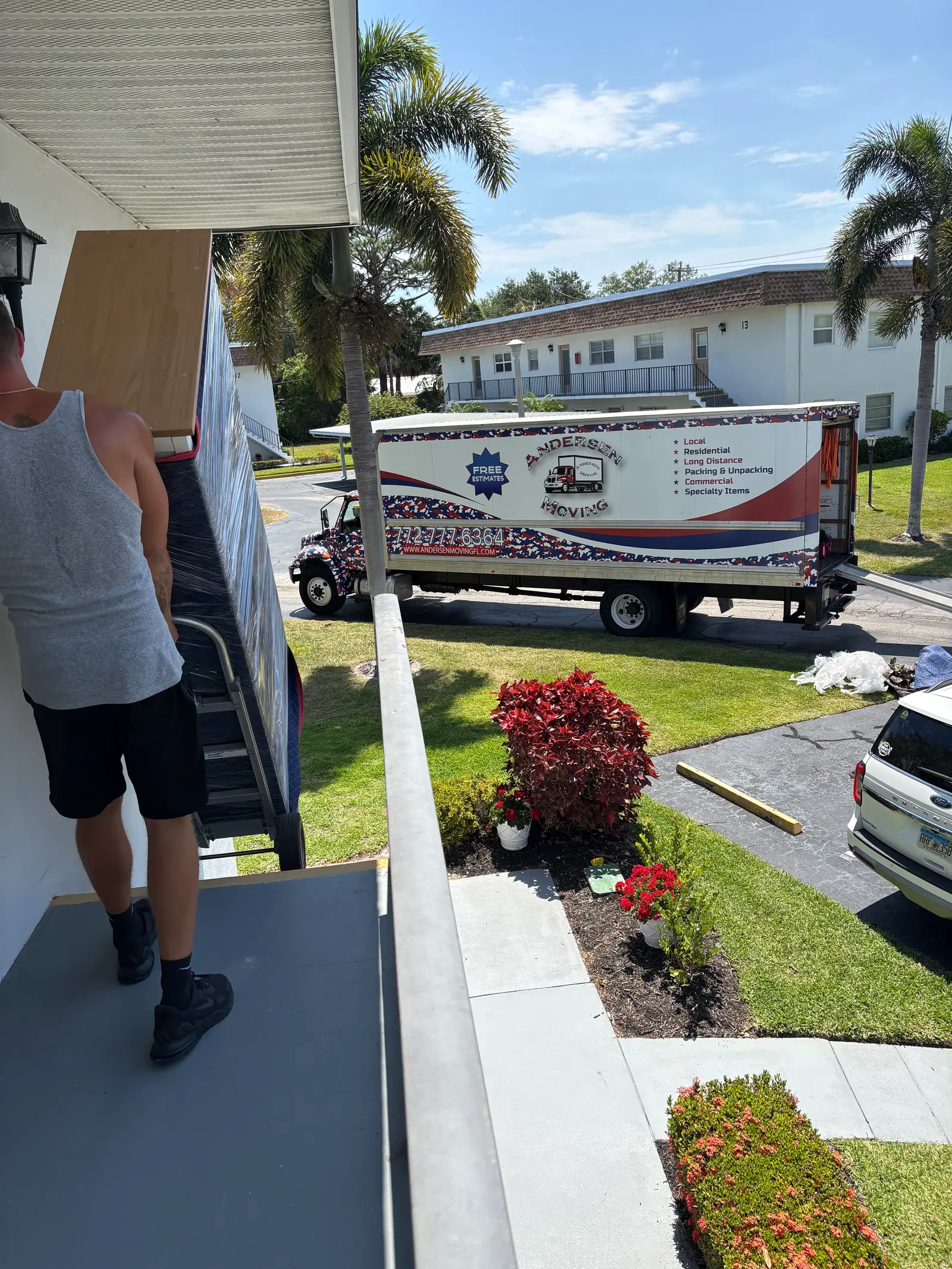 Andersen Moving crew carrying wrapped furniture into a Treasure Coast home